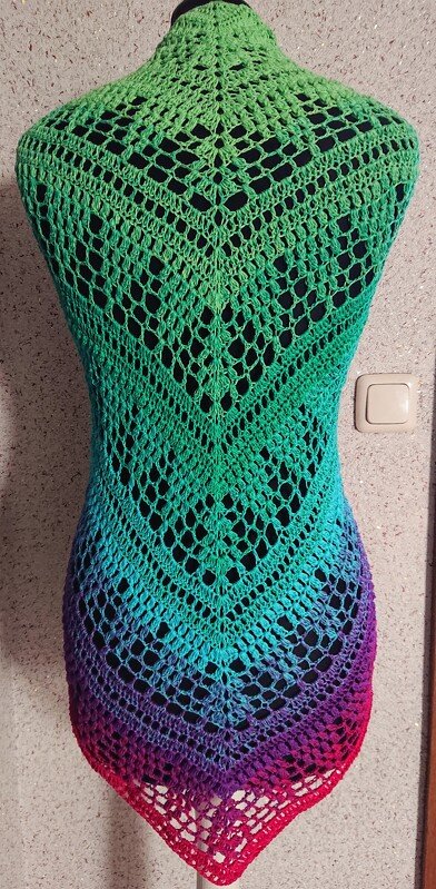 Gehäkeltes Dreieckstuch mit Farbverlauf von Grün bis Rot und V‑förmigem Lochmuster auf Schaufensterpuppe