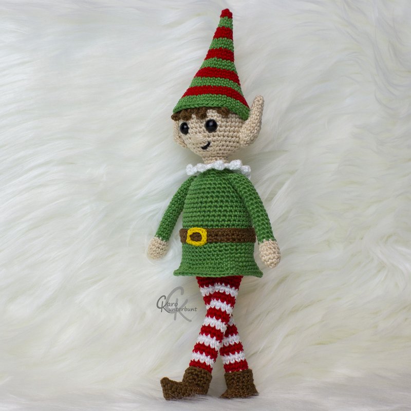 Amigurumi-Puppe: gehäkelter Elf mit grüner Tunika, braunem Gürtel, rot-weißen gestreiften Beinen und gestreifter Mütze
