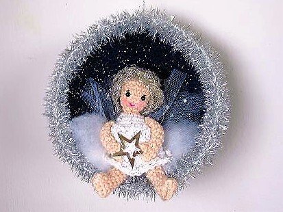 Gehäkeltes Amigurumi-Engelchen mit Tüllflügeln in runder Weihnachtskugel mit silbernem Rand