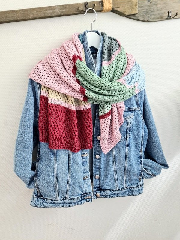 Langer gestrickter Schal mit Lochmuster und Pastellblockstreifen über einer Jeansjacke