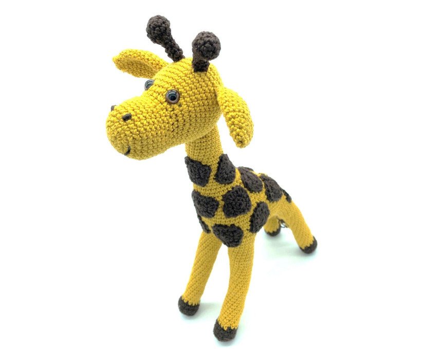Gehäkelte Amigurumi-Giraffe gelb mit braunen Flecken und eingesetzten Augen