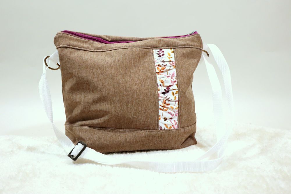 Braune Stoff-Umhängetasche mit weißem Gurt, Blättermotiv-Zierstreifen und violettem Reißverschluss