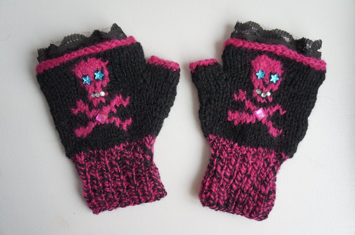 Schwarz-pinke fingerlose Armstulpen mit Totenkopf, blauen Sternen, glitzernden Steinchen und schwarzer Spitze