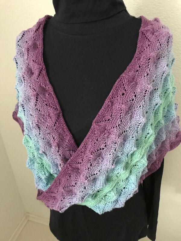 Gestrickter Loop mit Violett-zu-Mint-Farbverlauf und Ajourmuster auf schwarzem Oberteil