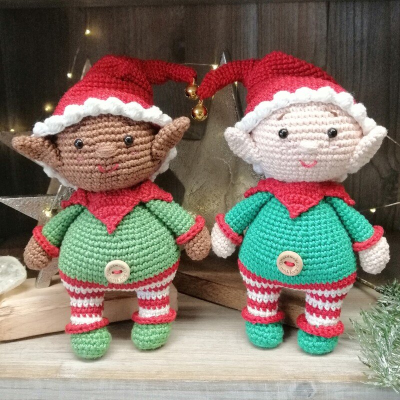 Zwei gehäkelte Amigurumi-Weihnachtselfen mit roten Zipfelmützen und Glöckchen