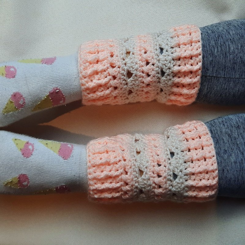 Gehäkelte rosa-creme Stulpen an Beinen, getragen über Socken mit Eismotiv und grauen Leggings