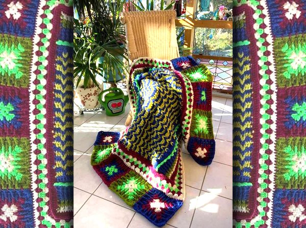 Bunte gehäkelte Decke mit Granny‑Squares und Zickzack‑Muster auf Korbstuhl in heller Veranda