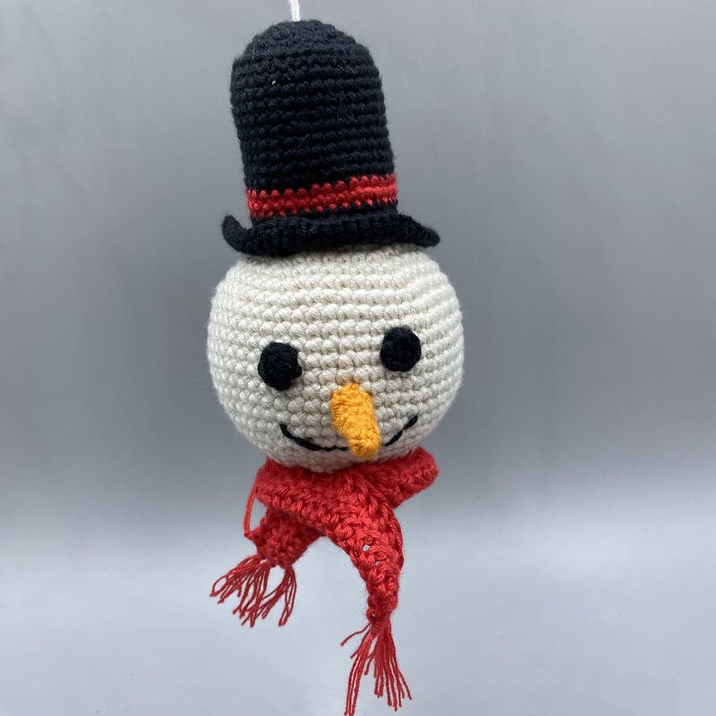 Gehäkelter Schneemannkopf mit schwarzem Zylinder und rotem Schal, hängend