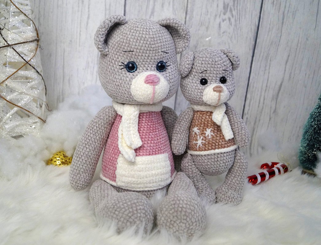 Zwei gehäkelte Amigurumi-Bären in Grau in unterschiedlicher Größe mit bestickten Gesichtszügen und kleinen Schals