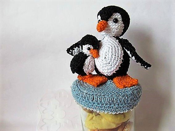 Gehäkelte Pinguin-Applikationen als Deckelüberzug auf einem Glas