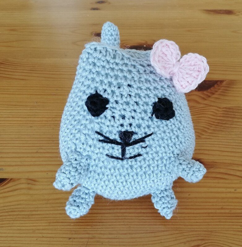 Gehäkelte graue Amigurumi-Katze mit rosa Schleife