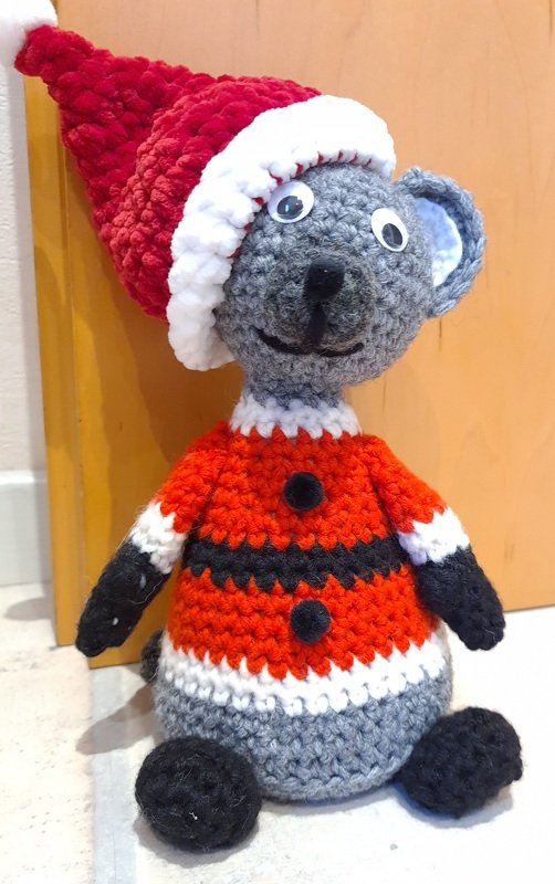 Gehäkelte Maus mit breiter runder Basis, roter Mütze und Weihnachtskostüm, als Türstopper verwendet