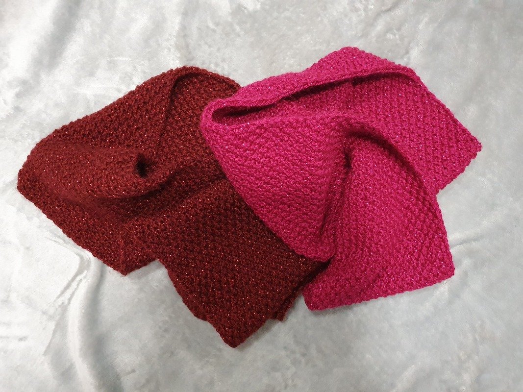 Zwei glitzernde Loops in Dunkelrot und Fuchsia auf hellem Untergrund