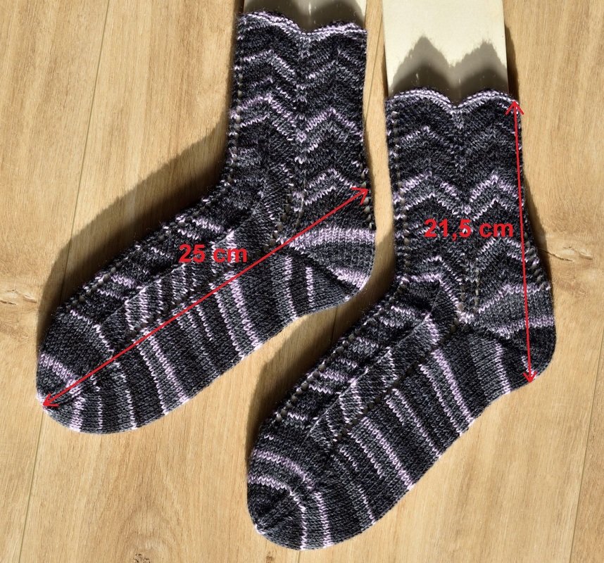 Referenzfoto von zwei gestrickten Socken mit Zickzackmuster und markierten Maßen: Fuß 25 cm, Schaft 21,5 cm