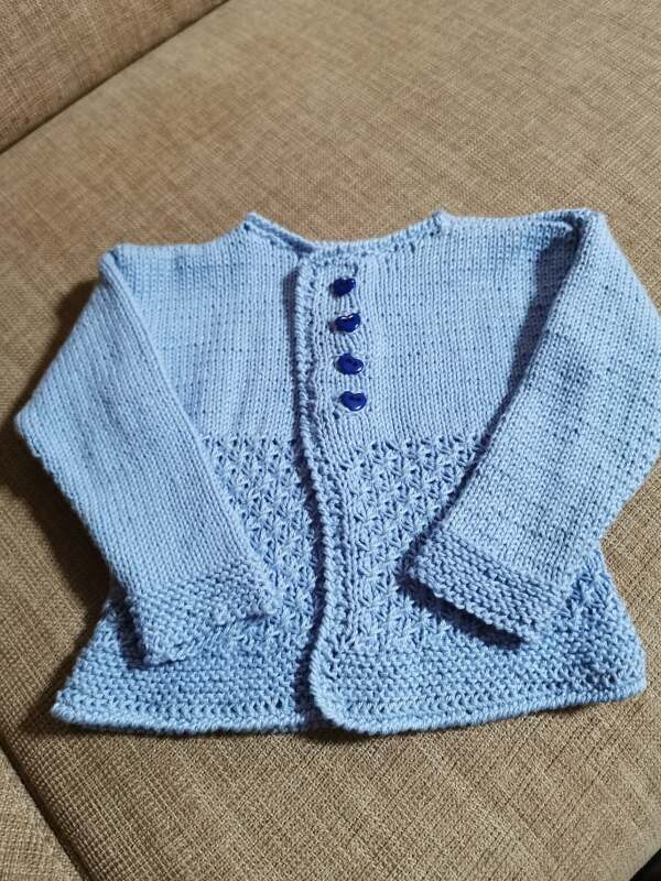 hellblaue gestrickte Babyjacke mit vier dunkelblauen Knöpfen und Lochmuster