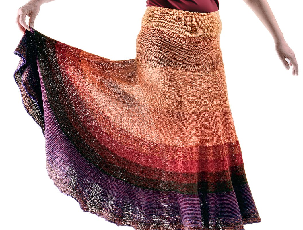 Gestrickter Tellerrock mit hohem Rippbund und abgestuftem Farbverlauf von Orange bis Violett, seitliche Ansicht