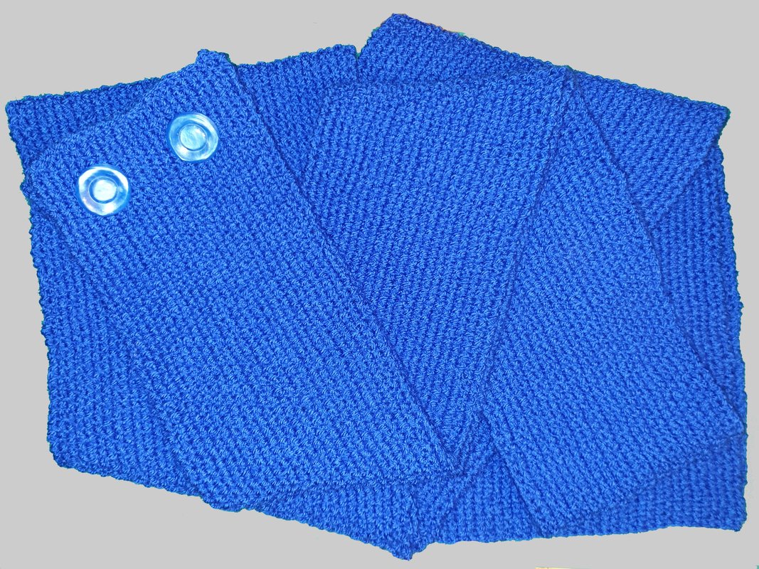 Blauer gestrickter Halsschal mit zwei hellen Knöpfen und diagonal wirkender Maschenstruktur