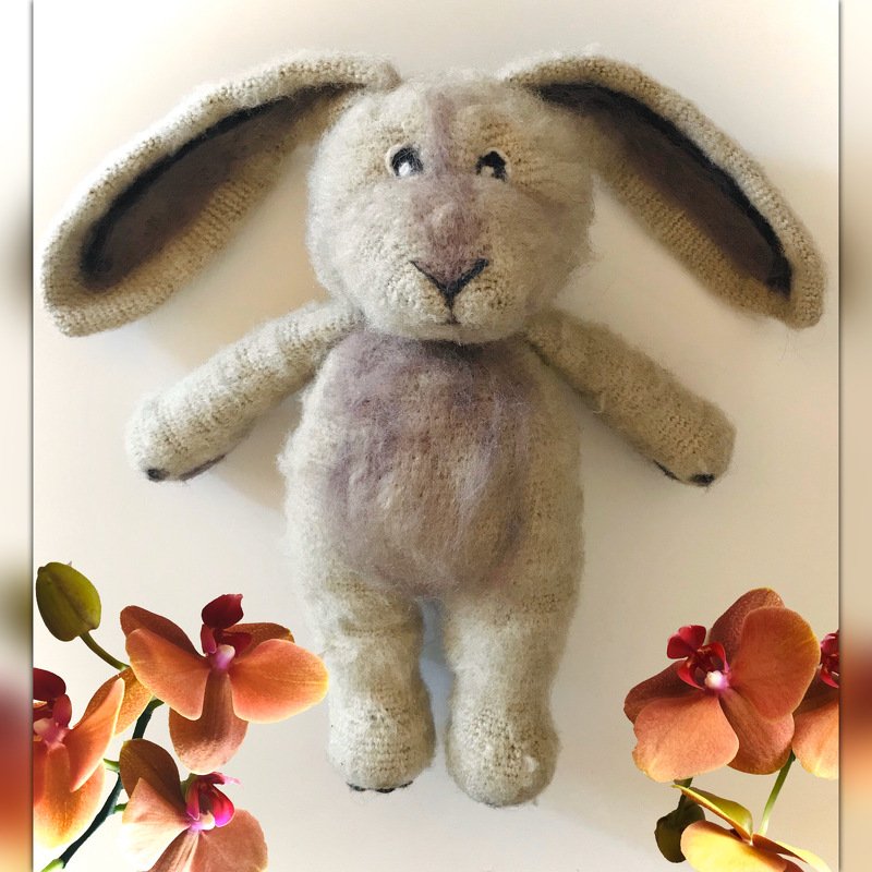 Gehäkelter Amigurumi‑Hase in Beige mit langen Schlappohren und gestickten Gesichtszügen