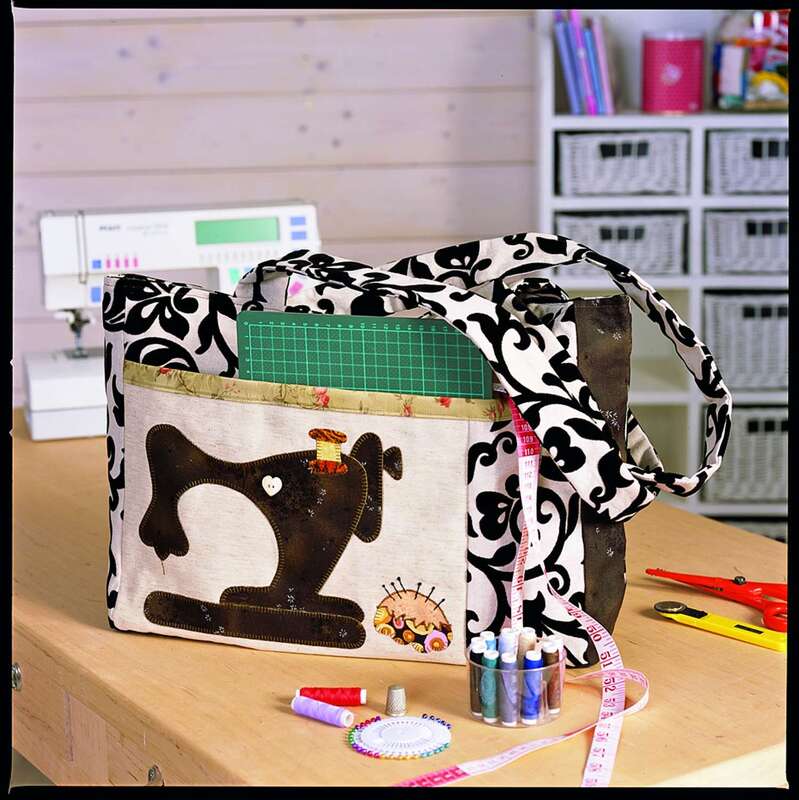 Schwarz-weiß gemusterte Utensilo-Tasche mit applizierter Nähmaschine, Schneidematte, Maßband und Garnrollen