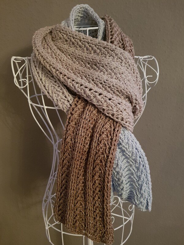Gehäkelter Schal in Hellblau, Beige und Braun auf weißer Drahtbüste