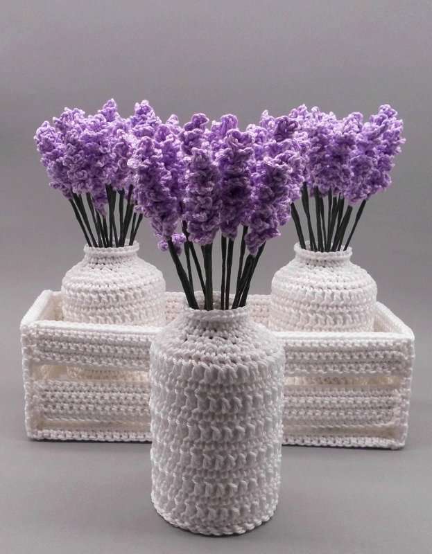 Three white crocheted vases in a tray with purple crocheted lavender-style stems