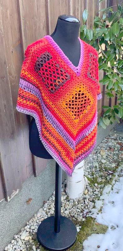 Gehäkelter V-förmiger Poncho mit Diamantlochmuster und farbigen Streifen auf Mannequin