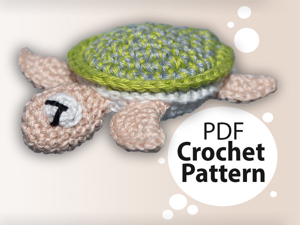 Gehäkelte Amigurumi-Schildkröte mit grün-grauem Panzer und rosa Körper, daneben ein Kreis mit dem englischen Schriftzug „PDF Crochet Pattern“.