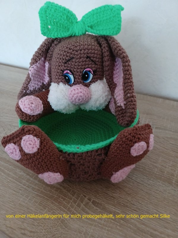 Brauner gehäkelter Hase mit grüner Schleife und grünem Innenkorb