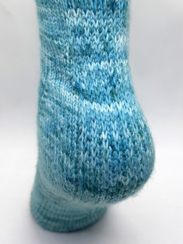Fersenansicht einer blau melierten gestrickten Socke, Nahaufnahme