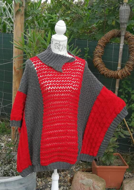 Gestrickter roter und grauer Poncho-Pullover auf Schaufensterpuppe mit Ajourmuster und Rippbündchen