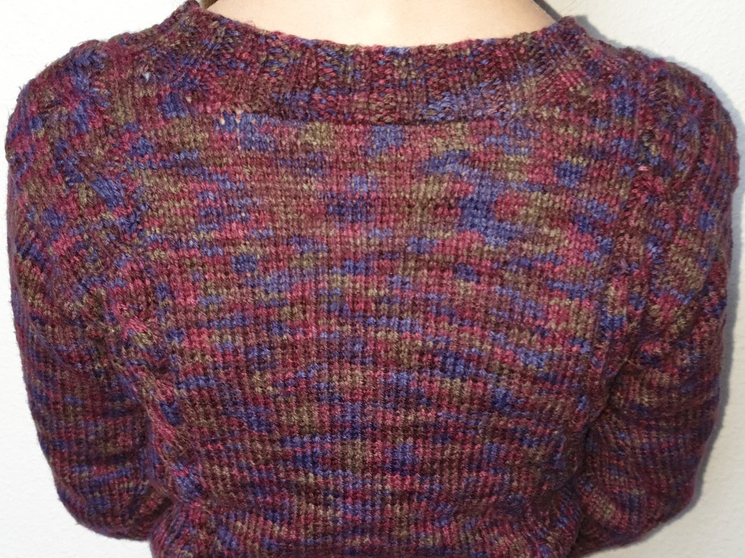 Rückenansicht eines mehrfarbigen Strickpullovers aus meliertem Garn in Weinrot, Violett und Olivgrün.