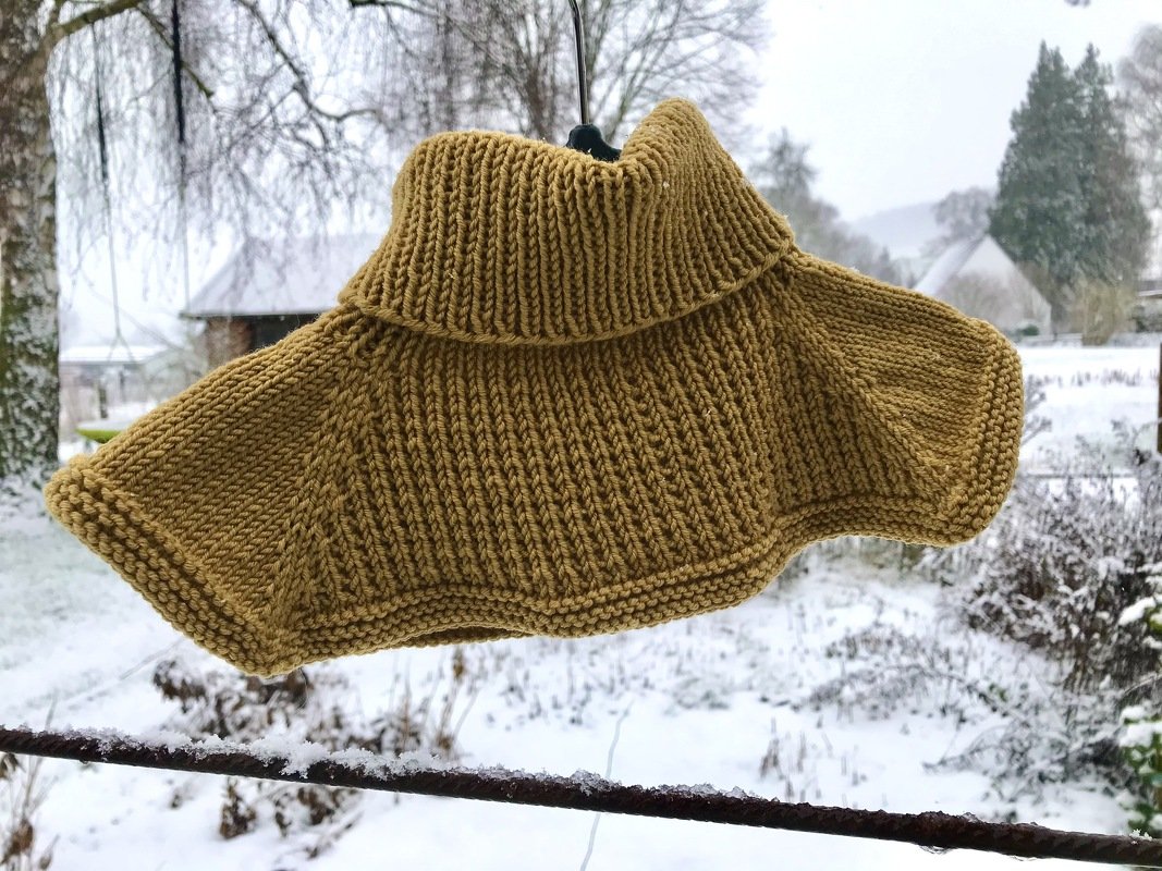 Senfgelbes Kindercape gestrickt mit hohem Rollkragen und Rippenmuster
