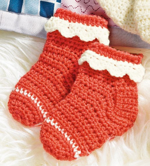 Paar gehäkelter Babysocken in Korallenrot mit weißer Zackenborte