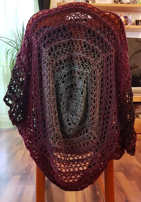 Gehäkelter Seelenwärmer in Bordeaux und Anthrazit mit Lochmuster, auf einer Stuhllehne drapiert