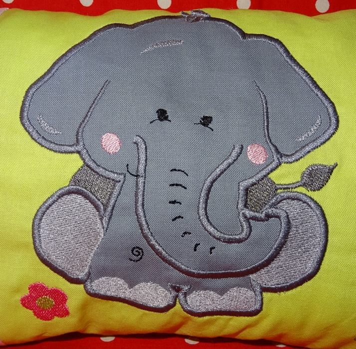 Applizierter grauer Elefant mit rosa Bäckchen und roter Blume auf gelbem Stoff