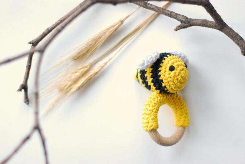 Handgehäkelte Biene auf Holzring, gelb-schwarz gestreift mit weißen Flügeln