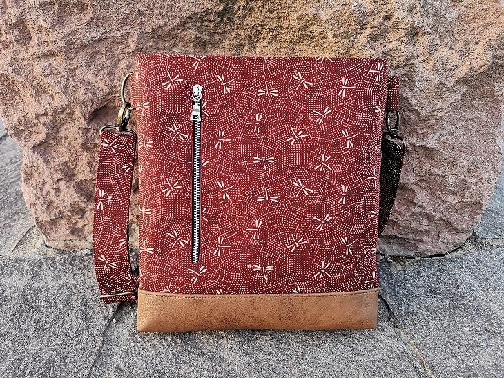 Rote Crossbody-Tasche mit senkrechtem Außenfach und hellbraunem Boden