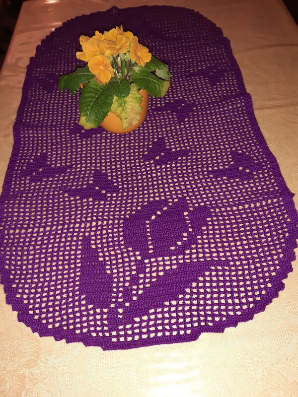 Lila gehäkelter Tischläufer im Filetmuster mit Tulpenmotiven und gelber Topfpflanze