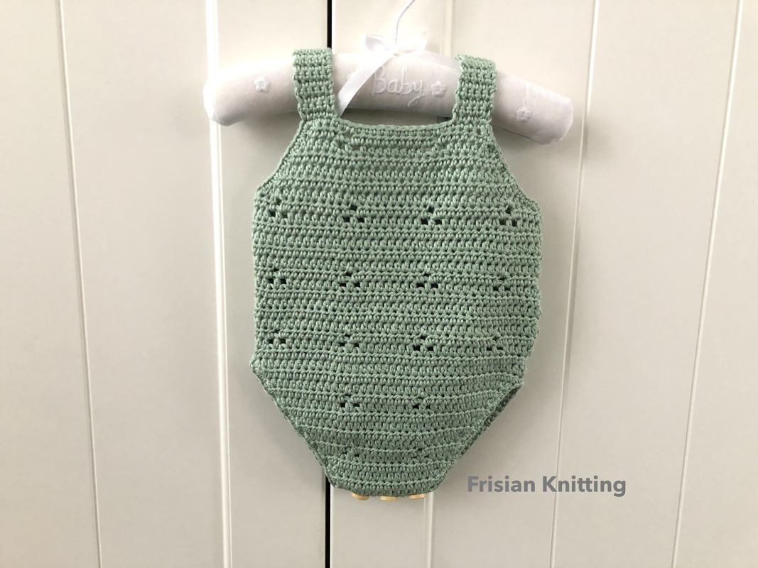 Light green crocheted baby romper on padded baby hanger.
