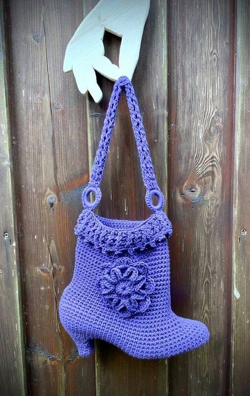 Lila gehäkelte Henkeltasche in Stiefel‑Form mit Blütenapplikation und Rüschenrand