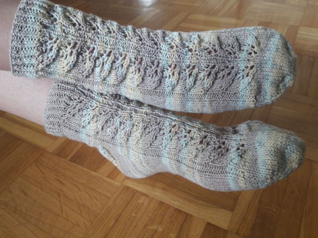 Nahaufnahme gestrickter Kniestrümpfe mit Ajourstreifen, Bündchen und Spitze