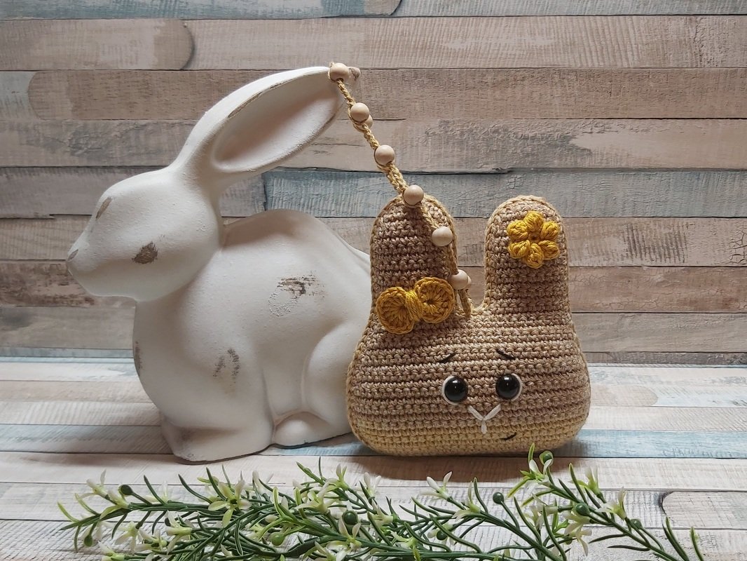 Gehäkelter Osterhase in Braun mit gelben Blumen und Holzperlenkette