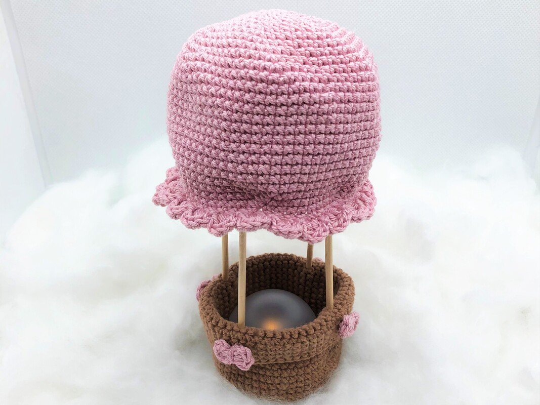 Gehäkelter rosa Heißluftballon Amigurumi mit braunem Korb und Holzstäbchen