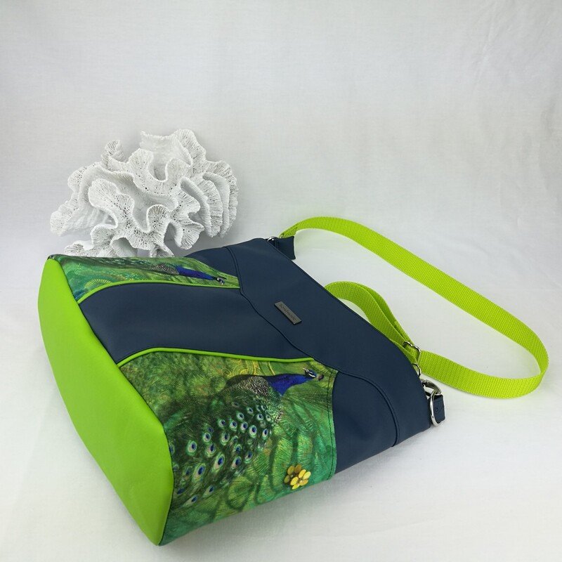 Dunkelblaue Schultertasche mit Pfauenmotiv und limettengrünem Boden und Tragegurt