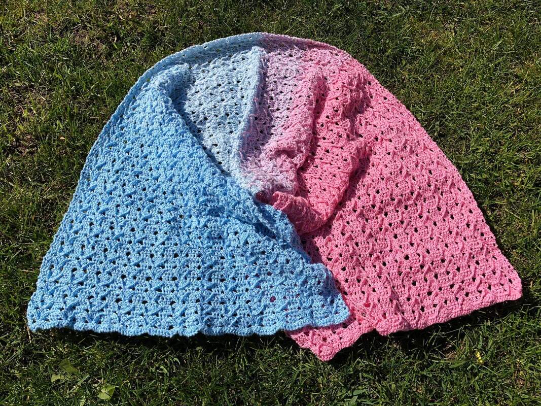 Handgehäkelter Schal in Blau, Lila und Rosa mit Lochmuster auf grüner Wiese