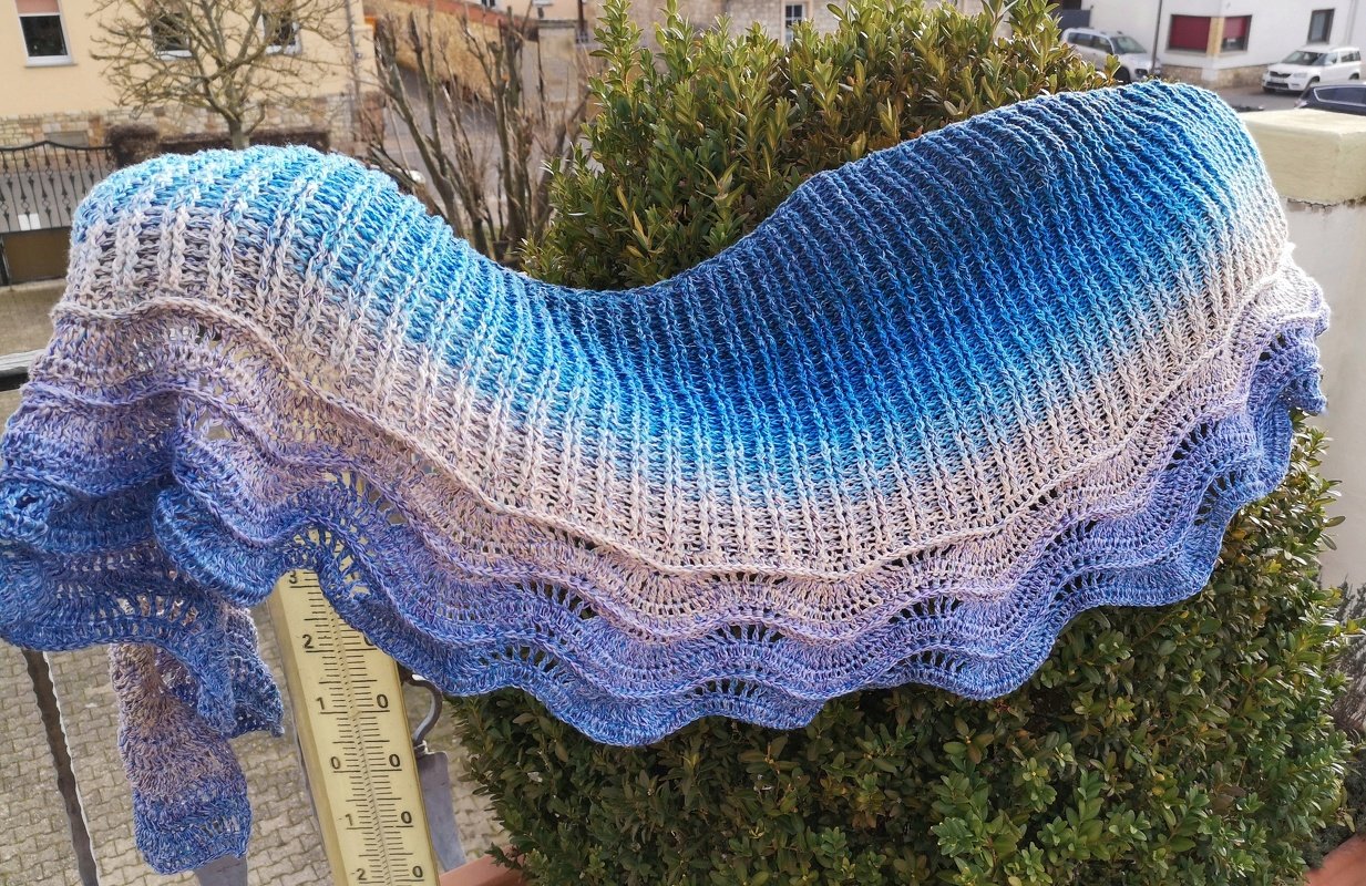 Halbrundes Häkel­tuch mit Rippenstruktur und gewelltem Saum in Blau-Lila-Verlauf, Lineal neben dem Tuch sichtbar