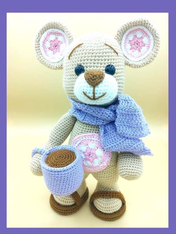 Detailansicht Amigurumi-Teddybär mit Blütenohren, Schal und Tasse