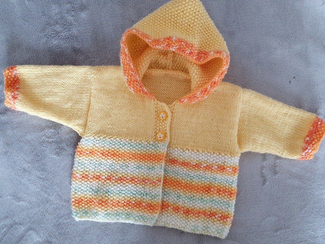 Gestrickte gelbe Babykapuzenjacke mit pastellgestreiften Partien und zwei Sternknöpfen