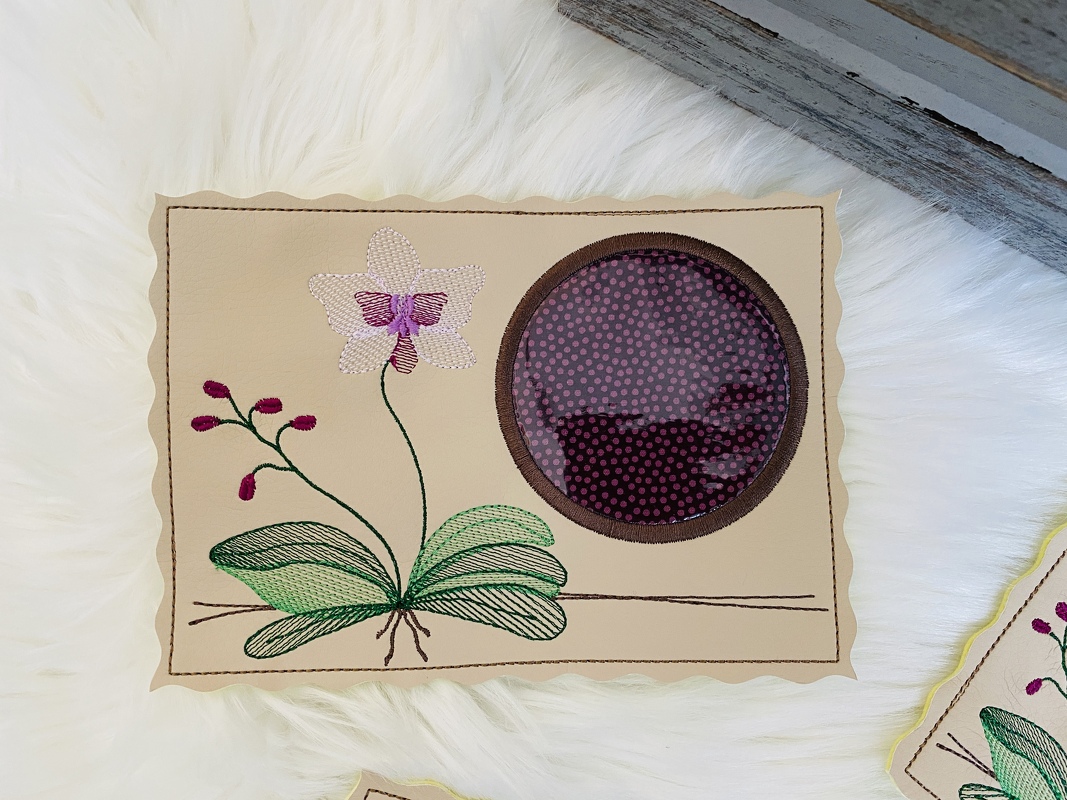 Beiger ITH-Tassenteppich mit gestickter Orchidee, gewelltem Rand und rundem Klarsichtfenster