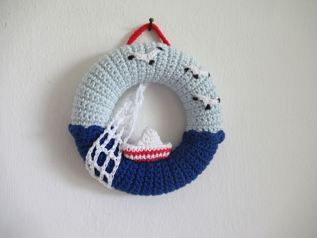 Gehäkelter blauer Türkranz mit kleinem Boot, Netz und Möwen